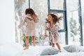 Jumping on bed. Two cute little girls indoors at home together. Children having fun Royalty Free Stock Photo