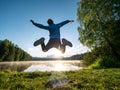 Jumping boy celebrate freedom and make fun at lake Royalty Free Stock Photo