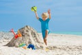 Jumping boy play with sand shovel bucket at the ocean beach Royalty Free Stock Photo