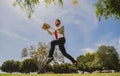 Jumping business man with laptop outdoor in park. Concept of fast internet with running businessman with a laptop. Royalty Free Stock Photo