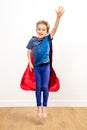 Jumping child flying like a fun super hero, saying hello