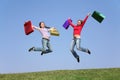 Jumping couple girls with bags