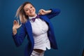 Jumping and dancing businesswoman in stylish blue jacket and bow tie. Portrait of a cheerful girl