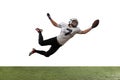 Portrait of American football player catching ball in jump isolated on white studio background. Royalty Free Stock Photo