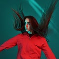 Jumping, hair is in the air. Studio shot indoors with neon light. Portrait of beautiful young girl Royalty Free Stock Photo