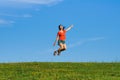 Jumping happy emotion woman on grass and sky backgrounds