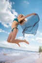 Jumping happy girl on the beach, fit sporty healthy body in bikini