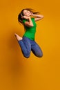 Jumping high, flying. Young woman's portrait on color studio background. Beautiful female model with headphones Royalty Free Stock Photo