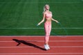 Jumping higher. athletic lady use jumping-rope on stadium. female athlete do jumping sport workout. trainer or coach