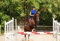 Jumping horse carrying horsewoman during training