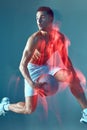 Jumping male basketball player with ball and naked muscular torso leaps to score. Long exposure. Motion blur Royalty Free Stock Photo