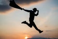 jumping man silhouette with hat and jacket dance against sunset sky, free Royalty Free Stock Photo