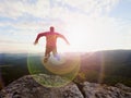 Jumping man. Young crazy man is jumping on rocky summit above landscape. Silhouette of jumping man Royalty Free Stock Photo