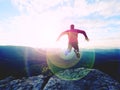 Jumping man. Young crazy man is jumping on rocky summit above landscape. Silhouette of jumping man Royalty Free Stock Photo