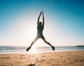 Jumping man. Young fitness man doing jumping jacks or star jump exercise on the beach Royalty Free Stock Photo