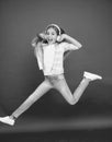 Jumping mid air. Easy listening music. Small girl listening to music in headphones. Dancing girl. Happy small girl Royalty Free Stock Photo