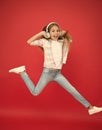 Jumping mid air. Easy listening music. Small girl listening to music in headphones. Dancing girl. Happy small girl Royalty Free Stock Photo