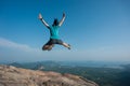 Jumping on rocky mountain peak