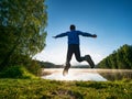 Jumping short hair boy at mountain lake makes fun Royalty Free Stock Photo