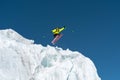 A jumping skier jumping from a glacier against a blue sky high in the mountains. Professional skiing Royalty Free Stock Photo