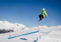 Jumping snowboarder with a blue and sunny sky in Zermatt, the swiss Alps Royalty Free Stock Photo