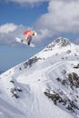 A jumping snowboarder in the mountains. Snowboarding, winter extreme sport.