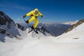 A jumping snowboarder in the mountains. Snowboarding, winter extreme sport. Royalty Free Stock Photo