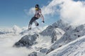 A jumping snowboarder in the mountains. Snowboarding, winter extreme sport.