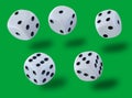 Jumping white dices thrown in a craps game, yatsy or any kind of dice game against a green background Royalty Free Stock Photo