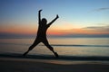 Jumping woman silhouettes with sunrise.