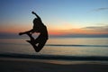 Jumping woman silhouettes with sunrise.