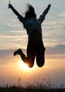 Jumping woman and sunset silhouett