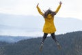 Jumping young woman on top of mountain. Concept of freedom. Happy tourist woman conquered the top Royalty Free Stock Photo