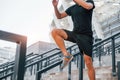 Jumps over obstacles. Young man in sportive clothes have workout outdoors at daytime