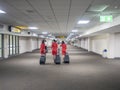 28 jun 20, Donmueng Airport, Bangkok, Thailand. Group of cabin crew in red uniform waking with trolley bag in empty terminal. Airp Royalty Free Stock Photo