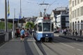 A blue tram at tram stop. People around there. Royalty Free Stock Photo