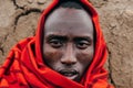 Masai or Maasai tribe man in red cloth portrait eyes staring at camera. Ethnic group of Ngorongoro Consevation, Serengeti in