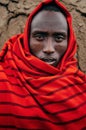 Masai or Maasai tribe man in red cloth portrait eyes staring at camera. Ethnic group of Ngorongoro Consevation, Serengeti in