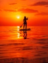 June 25, 2021. Anapa, Russia. Silhouette of woman paddle on stand up paddle board at quiet sea with sunset. Woman on Red Paddle