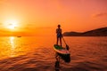 June 21, 2021. Anapa, Russia. Sporty woman paddle on stand up paddle board at sea with sunset or sunrise. Woman on Red Paddle sup