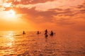 June 25, 2021. Anapa, Russia. Travelers on stand up paddle board at ocean with sunset or sunrise. Group on Red SUP boards and