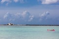 Dramatic image of man floating in a caribbean bay with a shipwreck boat in background.