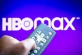 June 3, 2021, Brazil. In this photo illustration a person holds the TV remote control and in the background, the HBO Max logo Royalty Free Stock Photo