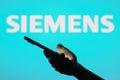 June 13, 2023, Brazil. Siemens logo seen in the background of a silhouette woman holding a mobile