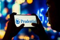 June 28, 2022, Brazil. In this photo illustration, a silhouetted woman holds a smartphone with the Prudential Financial logo