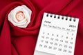 June 2024 desk calendar and pink rose on red textile Royalty Free Stock Photo