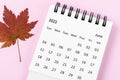 The June 2023 desk calendar for 2023 year with autumn maple leaf on pink color background