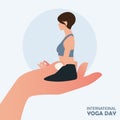 21 June International yoga day banner or poster with large human hand carrying young short hair woman sitting in meditation pose.