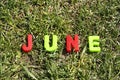 June letters from plastic on a background of green grass lie on the grass
