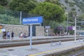 Monterosso sign on the railway platform across the trains, station infrastructure, and passengers with suitcases Royalty Free Stock Photo